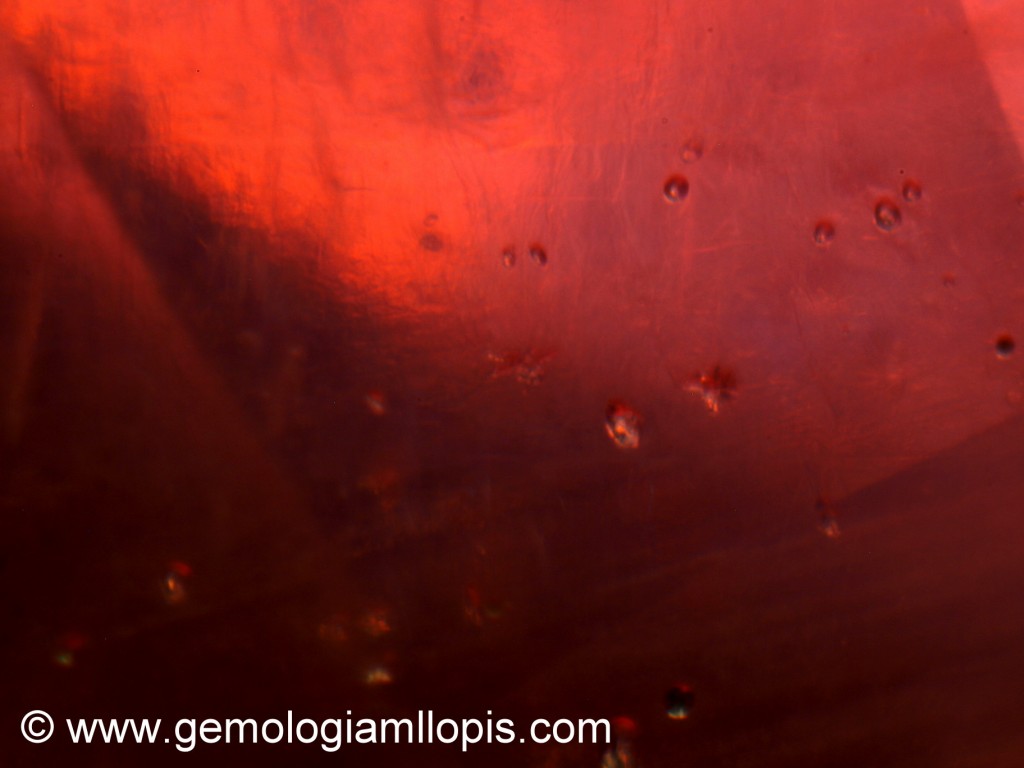 Burbujas y aspecto jaraboso en un rubí relleno de vidrio