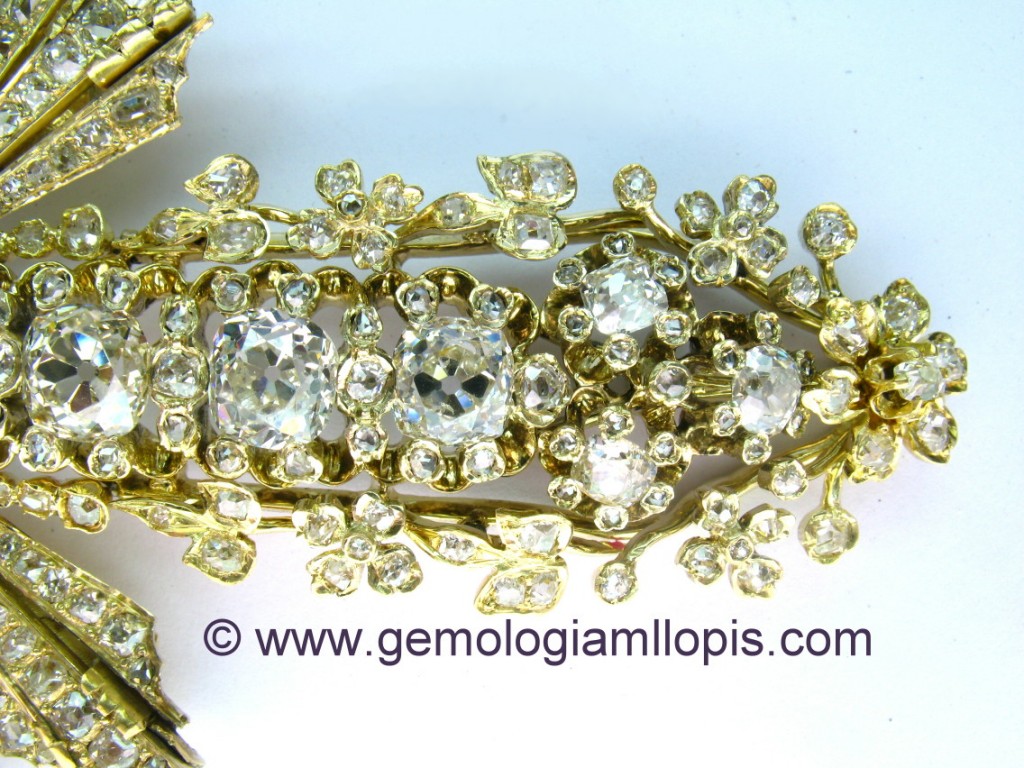 Detalle del pie de la cruz pectoral  de diseño floral con diamantes.