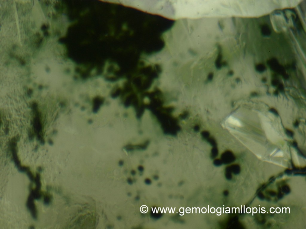 Manchas verdosas en la superficie de un diamante en bruto tratado por irradiación