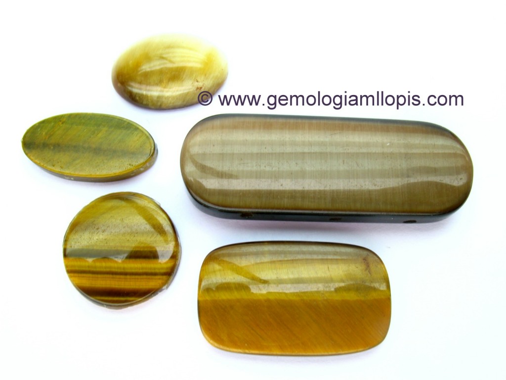 Ejemplares de cuarzo "ojo de tigre" y una cuenta doble cabujón oval de fibra de vidrio.