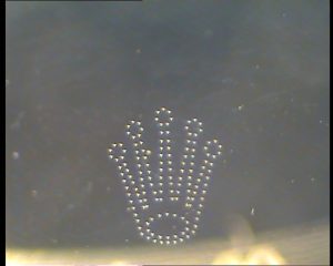 Grabado dcel logotipo en el interior de un cristal de una réplica de Rolex Daytona